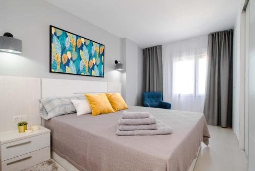 Un dormitorio blanco con una cama con toallas. en Espanatour MERUYERT, en Torrevieja