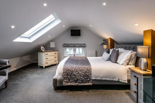 1 dormitorio con 1 cama grande y tragaluz en The Old Roller Shed en Cartmel