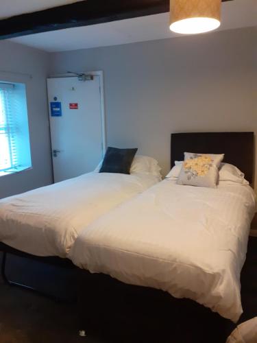two beds sitting next to each other in a bedroom at Crossroads House in Carlisle