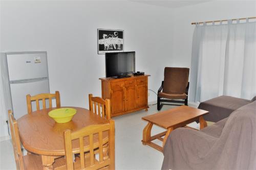 sala de estar con mesa y sillas y cocina en Apartamentos herederos Lm, en Caleta de Sebo