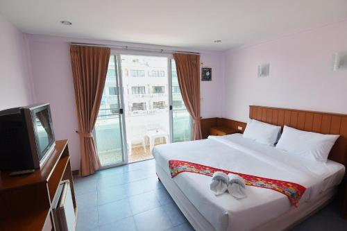 a bedroom with a large bed and a television at Cha-Am Fish Star in Cha Am