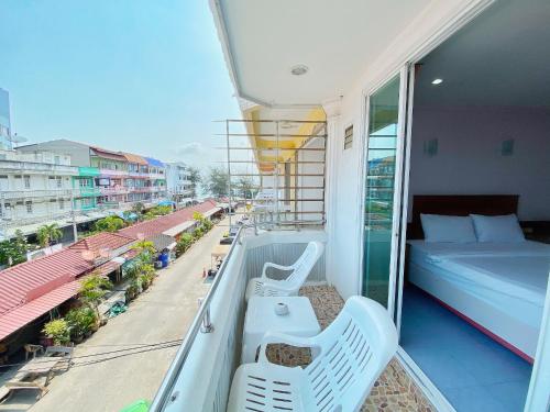 a balcony with a bed and two chairs on a balcony at Cha-Am Fish Star in Cha Am