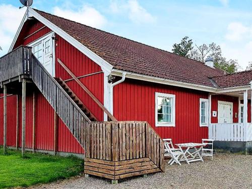 a red barn with a wooden ramp and a table at 5 person holiday home in LAMMHULT SVERIGE in Förhult