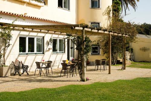a patio with chairs and a table in front of a building at Lisbon Country Villa in Oeiras