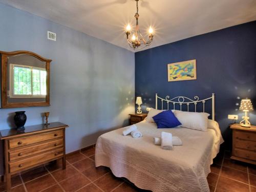 フリヒリアナにあるBelvilla by OYO Cortijo Albaricoqueのベッドルーム1室(青い壁のベッド1台、鏡付)