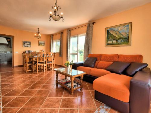 ein Wohnzimmer mit einem Sofa und einem Tisch in der Unterkunft Belvilla by OYO Cortijo Albaricoque in Frigiliana