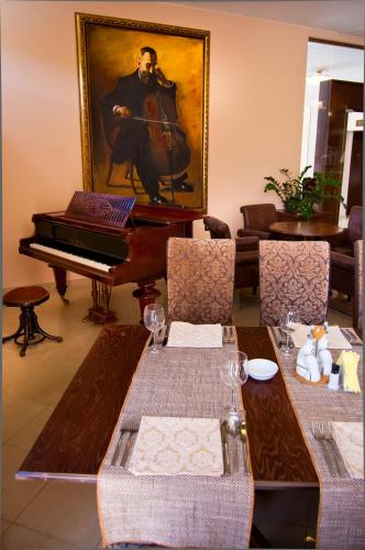 a dining room with a table and a piano at Hill Hotel Wellness & Spa in Jagodina