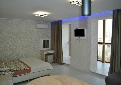 um quarto com uma cama e uma televisão na parede em apart-hotel Sky em Yuzhne