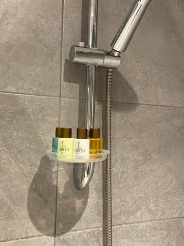 a metal pole with three bottles on a shelf on a wall at Liberi Hotel Taksim in Istanbul