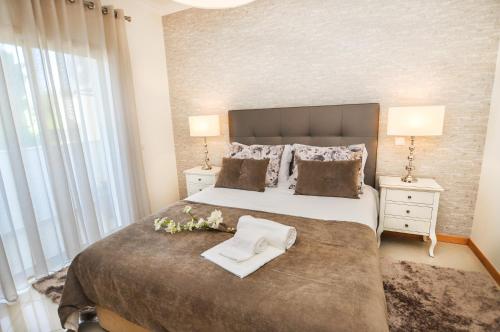 ein Schlafzimmer mit einem großen Bett mit Blumen darauf in der Unterkunft Encosta da Orada by OCvillas in Albufeira