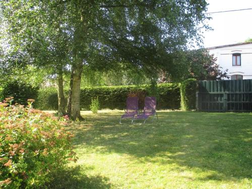 two purple chairs sitting in a yard under a tree at Rêve d'Authie in Dompierre-sur-Authie