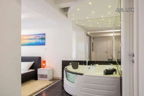 a bathroom with a bath tub and a bedroom at City Holliday Lux in Belgrade