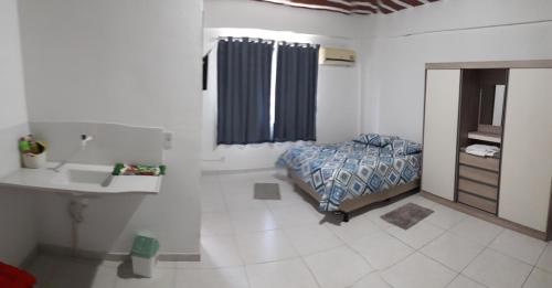 um quarto com uma cama e uma casa de banho com um lavatório em Fort em Angra dos Reis