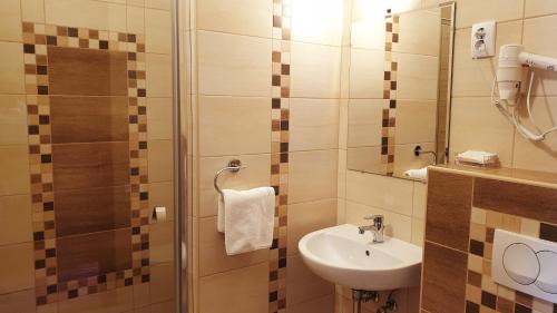 a small bathroom with a sink and a mirror at Diana Club Hotel in Budapest