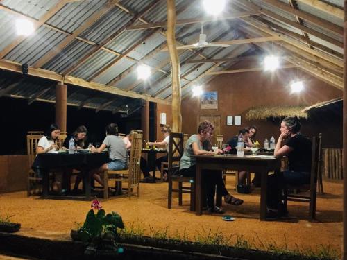 a group of people sitting at tables in a restaurant at Jaye Eco Lodge in Habarana