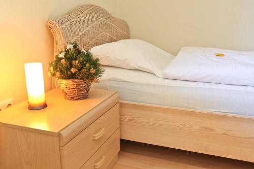 ein Schlafzimmer mit einem Bett und einer Kerze auf einer Kommode in der Unterkunft Ferienwohnung Haus Datz in Berchtesgaden in Berchtesgaden