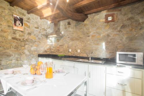 a kitchen with a white table and a microwave at Mortazel River Houses in Montazel