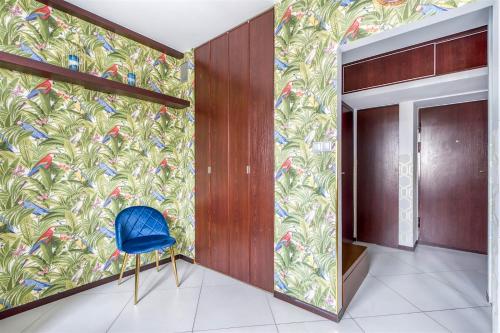 a blue chair in a hallway with a colorful wall at ClickTheFlat Palace of Culture View Apartment - Marszałkowska St. in Warsaw
