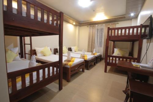 a room with four bunk beds in it at Monte casa de Rico in Vigan