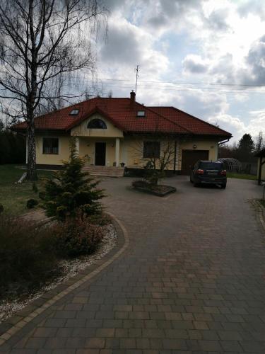 a house with a car parked in a driveway at Willa na Jurze in Zarki Letnisko