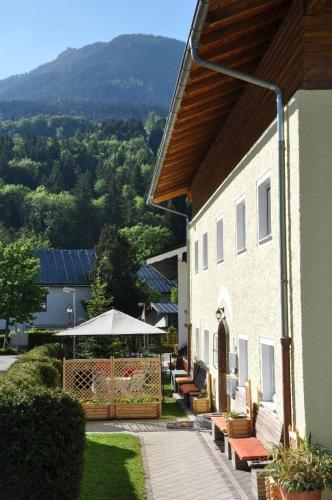 a building with a patio with benches and an umbrella at Ferienwohnung Haus Datz in Berchtesgaden in Berchtesgaden