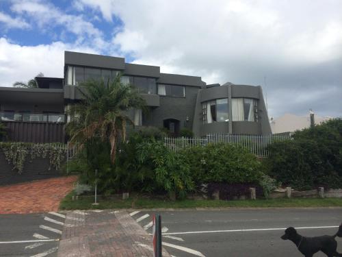 a house with a dog standing in front of a street at Seaview Place Bed and Breakfast in East London