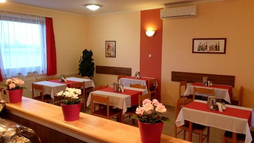 a restaurant with red and white tables and flowers at Diana Club Hotel in Budapest