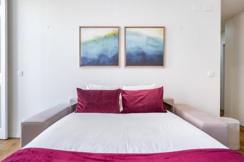 sypialnia z białym łóżkiem z fioletowymi poduszkami w obiekcie WHome | Alcântara Premium Studio w Lizbonie