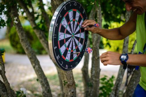 a man holding a dartboard in front of a tree at Hotel Elitsa in Albena