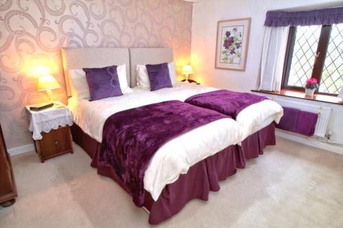 a bedroom with a large bed with purple sheets at Mellowvean in St. Agnes