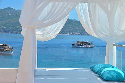 a bedroom with a view of the water and a boat at Kalamota Beach House in Koločep