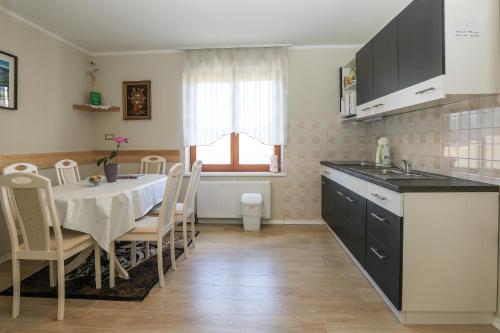 a kitchen with a table and chairs and a kitchen with a sink at Apartments Pr Fajfarju in Bled