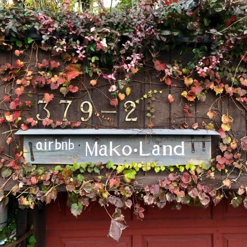 a sign on a door with flowers and plants at ガーデンハウス Mako Land in Toyama