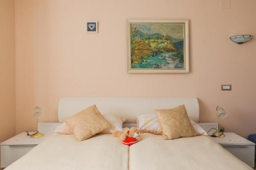 a white bed with a stuffed animal on top of it at Apartments Pr Fajfarju in Bled
