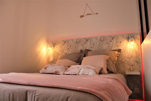 1 dormitorio con 1 cama grande con sábanas y almohadas rosas en Cocooning Studio, en Pontivy