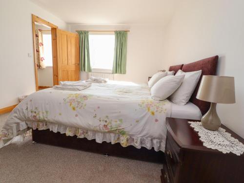 a bedroom with a large bed with a window at Zoey Cottage in Skipton