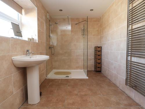 a bathroom with a sink and a shower at Zoey Cottage in Skipton