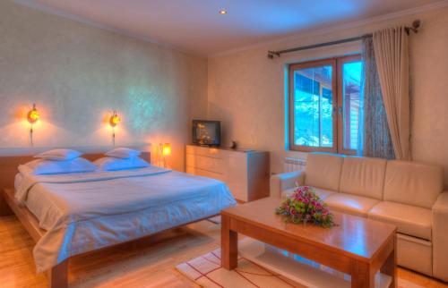 a bedroom with a bed and a couch at Ski Hotel in Žabljak
