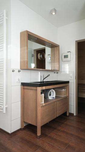 a kitchen with a sink and a mirror at Ferienhaus direkt am See - Kamin, Klima, Sauna und Boot in Friedland