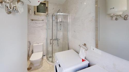 a white bathroom with a shower and a toilet at Marina Suite in Santa Cruz de Tenerife