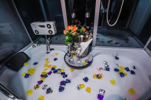 a sink with a vase of flowers and rocks at GolfView Suites & Conference Center in Ikeja