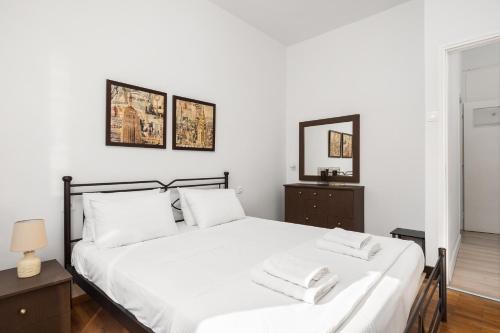 a bedroom with a white bed with two towels on it at Alsos Family Apartment in Corfu