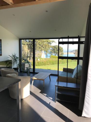 a living room with a couch and a table at Bellevues-Sur-Mer, à 100 m de la plage in Trévou-Tréguignec