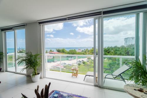 sala de estar con ventanas grandes y vistas al océano.  en AMARA CANCUN BEaCHFRONT CARIBE R, en Cancún