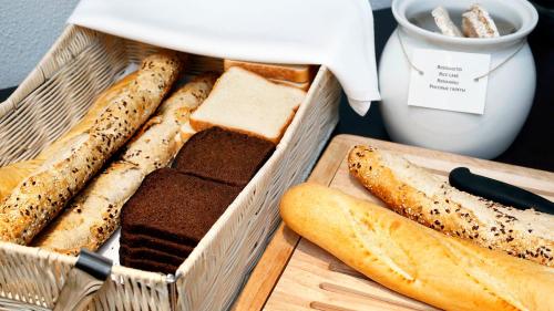 a basket of bread on a table with a cutting board at Hestia Hotel Ilmarine in Tallinn