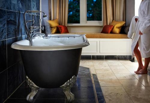 a bath room with a tub and a sink at Alexander House Hotel & Utopia Spa in Turners Hill