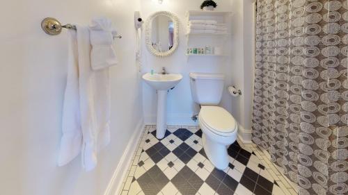 a white bathroom with a toilet and a sink at The Ocean Plaza Hotel in Ocean Grove
