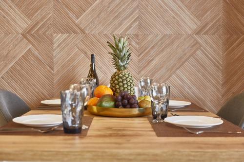 a table with a pineapple and a bowl of fruit at Gagarin Plaza Luxury Sea View Apartments in Odesa