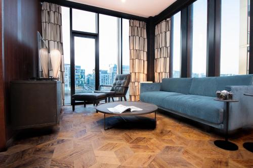 a living room with a blue couch and a table at The Mayson in Dublin