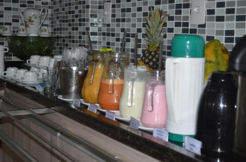 un bancone con tante bevande di diversi colori in barattoli di Hotel La Ville a Sousa